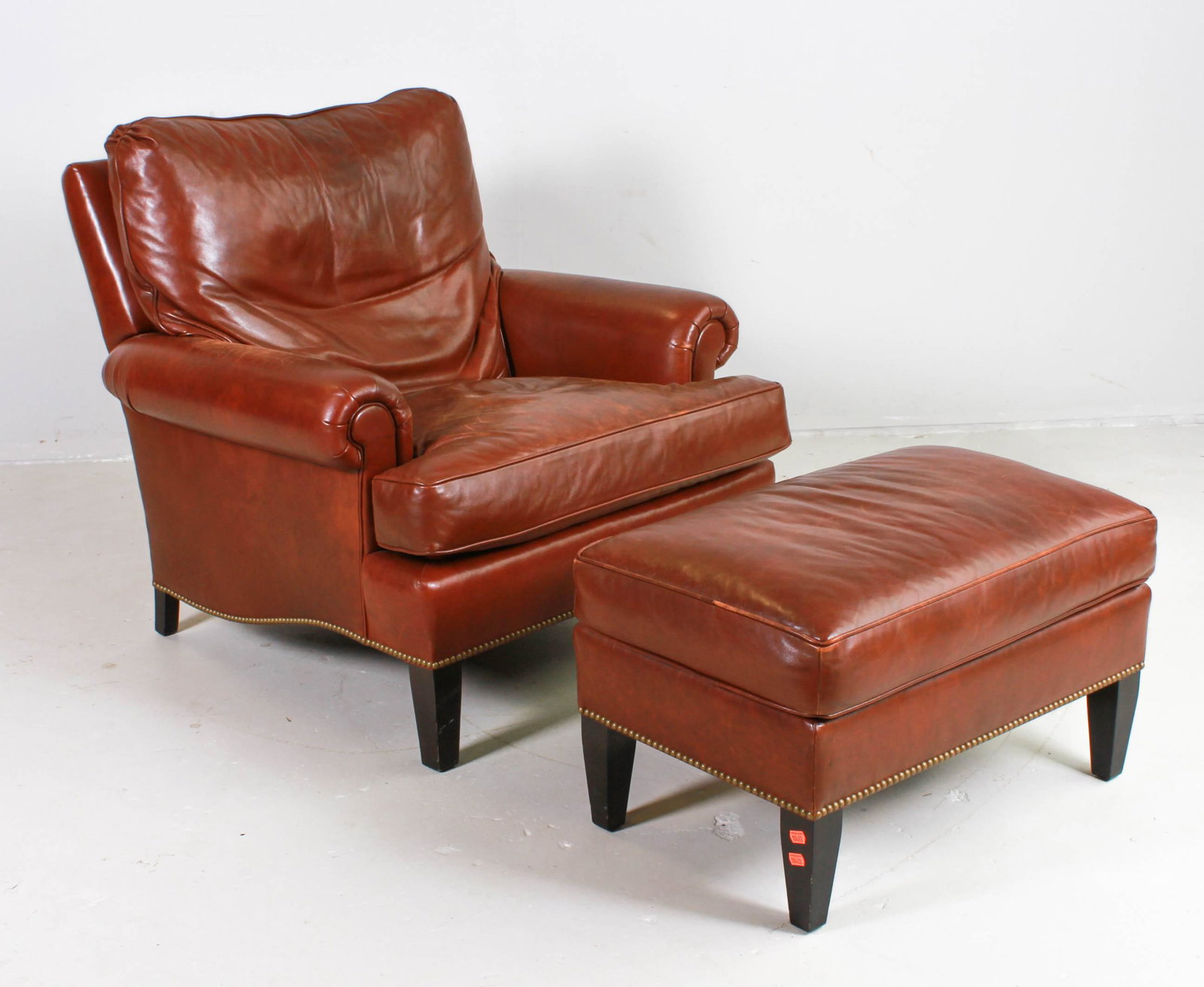 Beacon Hill leather lounge chair and ottoman: Beacon Hill Clarendon Court brown leather lounge chair and ottoman, brass tack bordered bases, chair 33"h x 36-1/2"w x 33"d, expected wear and scuffs to leather and legs