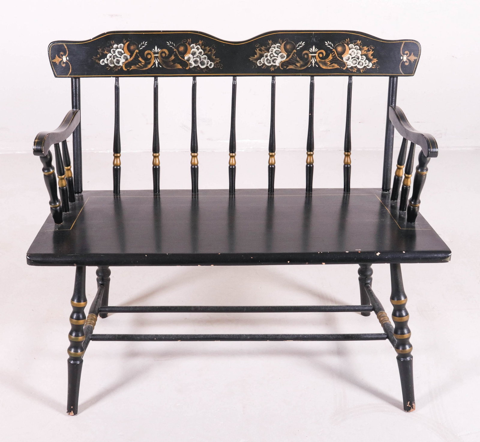 Ebonized and gilt spindle back bench: Ebonized and gilt spindle back bench, fruit stencil at crest, 34"h x 40"w x 17"d, wear to paint