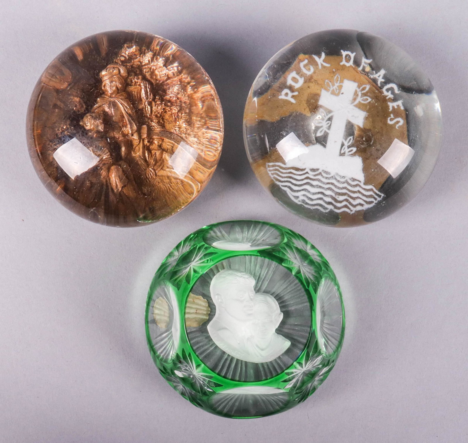 (3) Glass Paperweights: (3) Glass paperweights, c/o Cristal d'Albre France sulfide with John & Jackie Kennedy, sulfide Rock of Ages with cross, unmarked with 3D gilt courting scene, largest 3" dia
