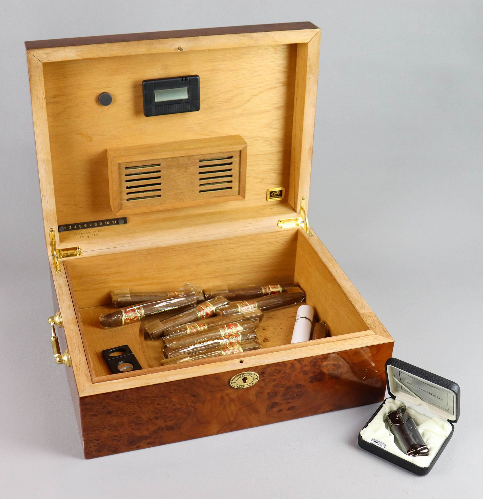 Daniel Marshall Burlwood Humidor: Daniel Marshall burlwood humidor, side brass bail handles, Series 1999 limited edition 19 of 199, 15-1/8" x 11-1/2" x 5-1/2" h, with (12) Fuente Fuente OpusX cigars, (1) Ashton Monarch cigar in tin ca