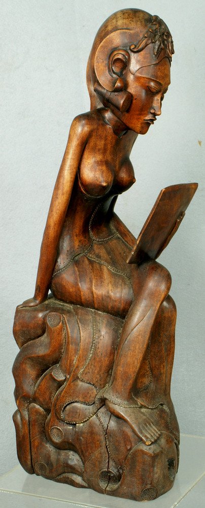 Carved Balinese figure of a nude woman reading, 20: Carved Balinese figure of a nude woman reading, 20" h, signed "BALI.D.1" on base, minor splits