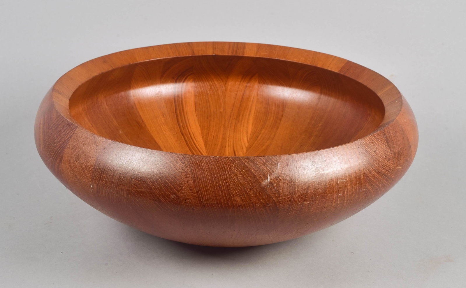 Dansk Teak Salad Bowl: Dansk teak wood salad bowl, Denmark, radiating laminated teak segments on turned bowl with incurvate rim, marked DANSK DESIGNS DENMARK IHQ on base, 16-1/2" dia x 6" h, scuffing on exterior