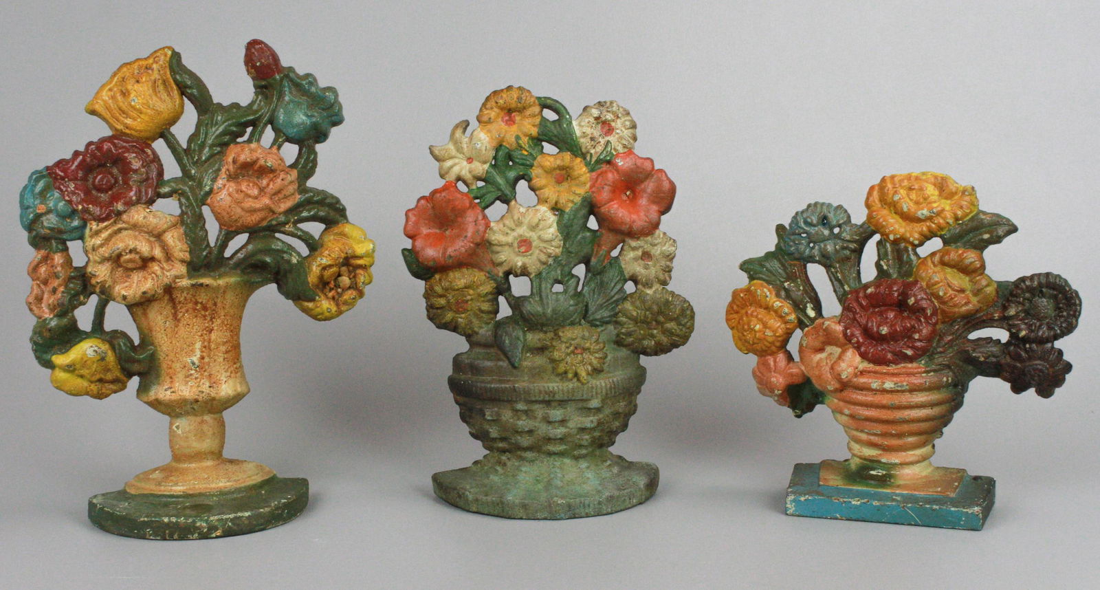 (3) Cast Iron Flower Basket Doorstops: (3) Cast iron flower basket doorstops, 7-1/4", 9" and 10" H