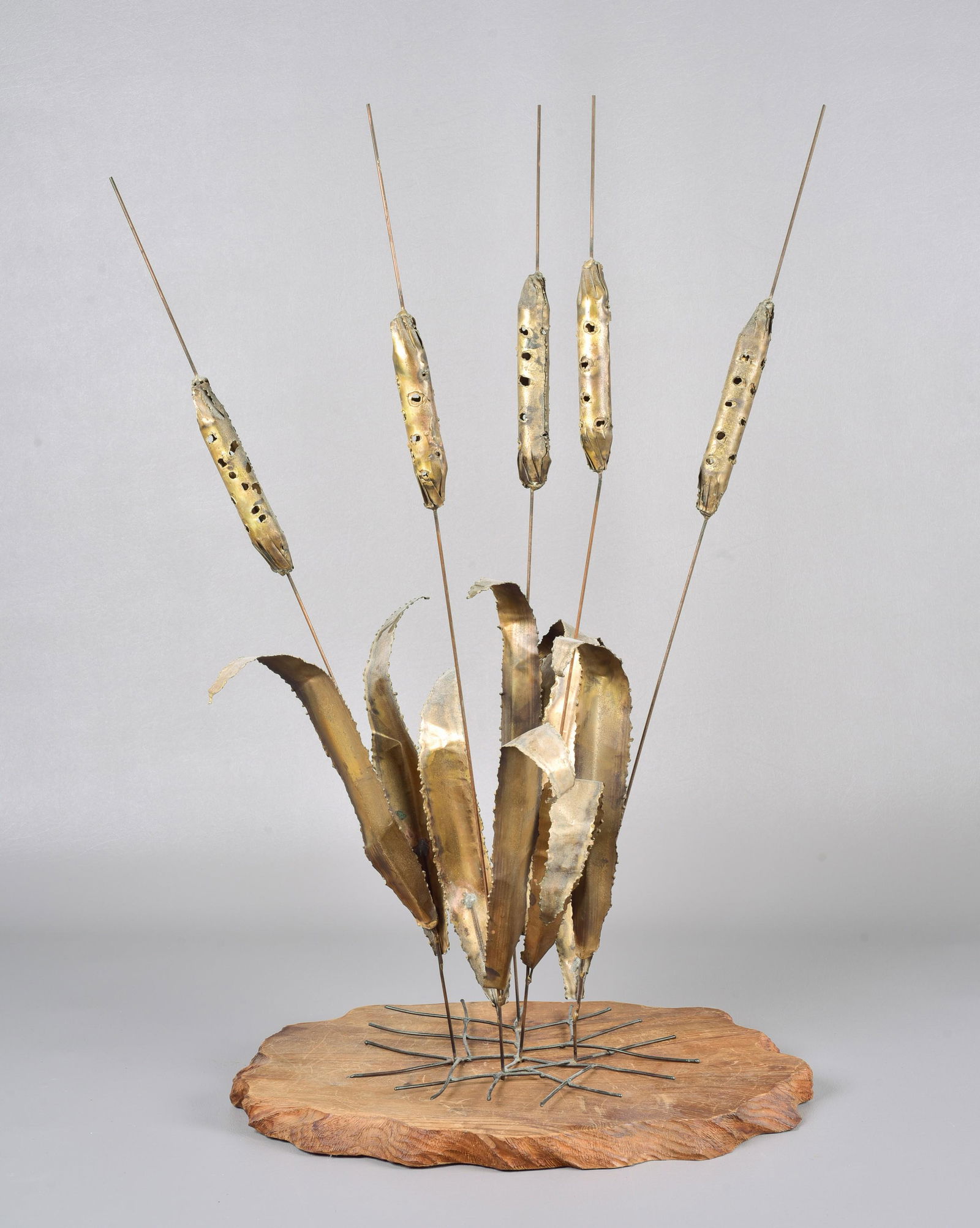Mixed Metal Cattails After Curtis Jere: Mixed metal cattails after Curtis Jere, rests on cut edge wood plinth, 27" H