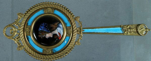 Gilt bronze hand mirror with enameled portrait of: Gilt bronze hand mirror with enameled portrait of a woman, guilloche enameled border and handle, 2 small bruises, 9" long