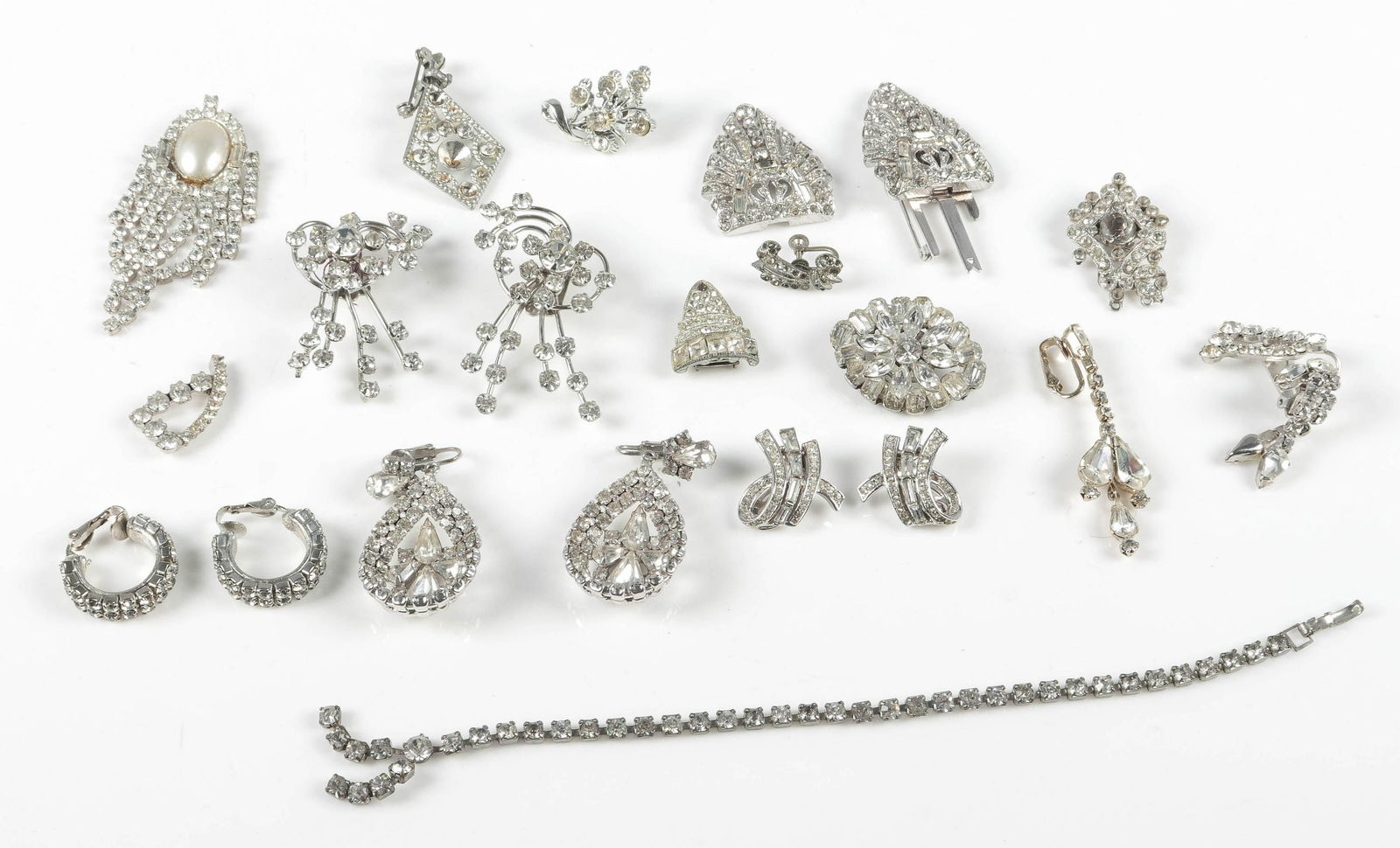 Rhinestone Costume Jewelry Lot: Rhinestone costume jewelry lot, (1) Pair of Trifari ear clips, (3) sets of unmarked earrings and misc. pieces for repair, restoration or parts.