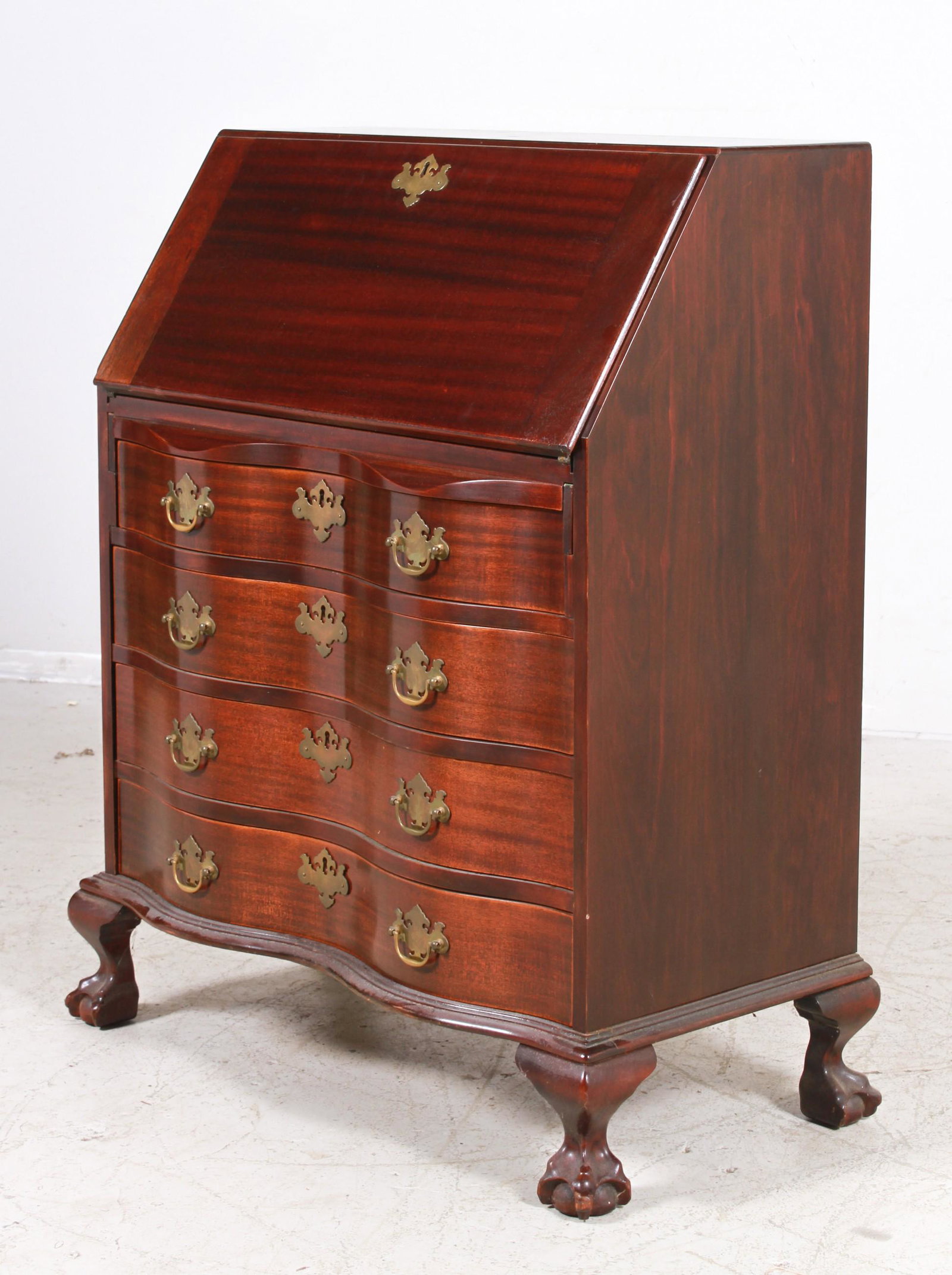Chippendale style serpentine slant front mahogany desk: Chippendale style serpentine slant front mahogany desk, fitted interior over 4-drawers on ball and claw feet, 40"h x 31"w x 17"d