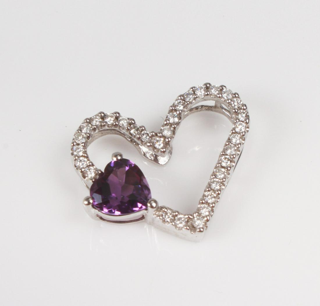 14K WG Open Heart Amethyst Pendant: A 14K WG Open heart and heart shape amethyst pendant. set with 31 round diamonds total: 0.21ct. 1.1dwts