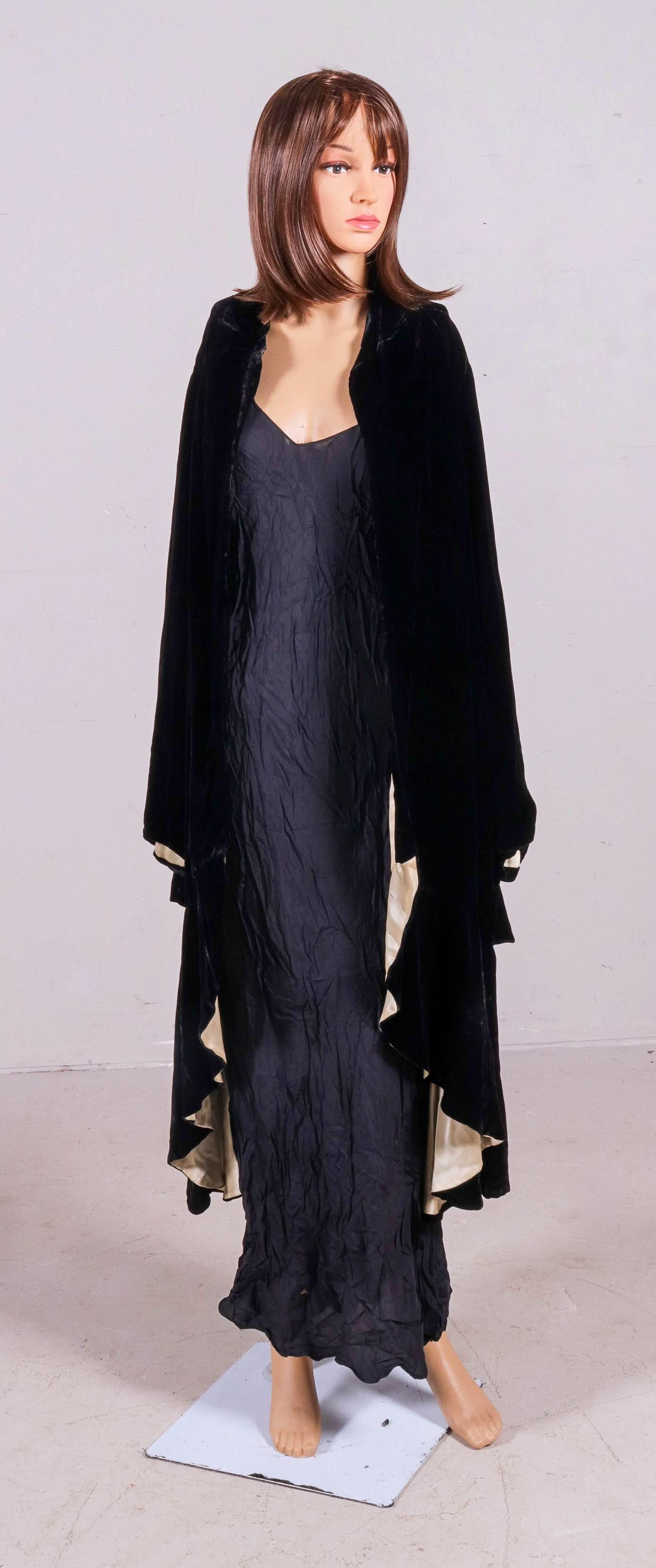 Early 20th C Franklin Simon and Co Velvet Opera Cape: Early 20th C Franklin Simon and Co. velvet opera cape, Fifth Avenue New York, in cocoon style comprised of black velvet with cream silk lining, ruffled sleeve hem, low gathered and flared hem, breaks 