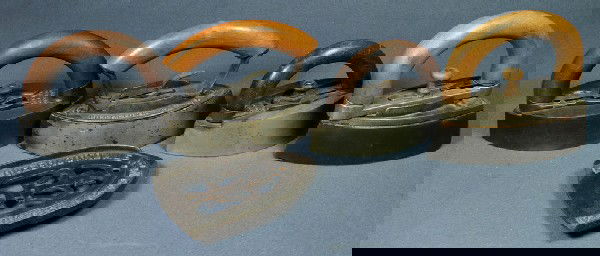 (4) Flat irons with removable wooden handles, Coleb: (4) Flat irons with removable wooden handles, Colebrookdale Iron Co, Pottstown PA on a matching trivet, with 3 others unsigned, longest 6 3/4"