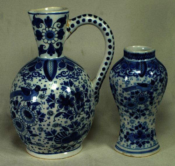 2 Dutch faience blue and white pcs to include a pi: 2 Dutch faience blue and white pcs to include a pitcher and a vase, pitcher measures 8"h and has repair to handle, 20th, marked to base