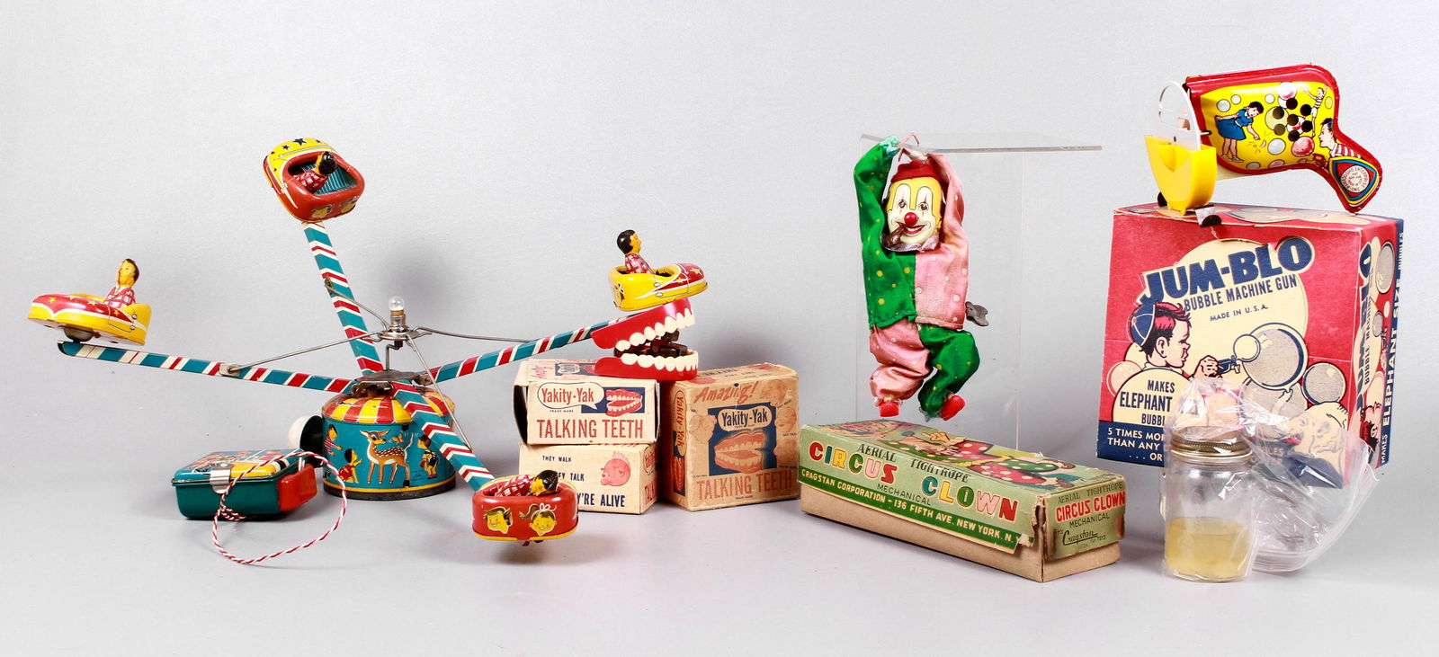 Circus Toy and Talking Teeth Grouping: Circus Toy and Talking Teeth grouping to include Alps Japan tin litho fair toy includes (4) riders in spinning cars, not currently running, (3) sets Yakity-Yak 1949 HF & Co made in Chicago USA wind up