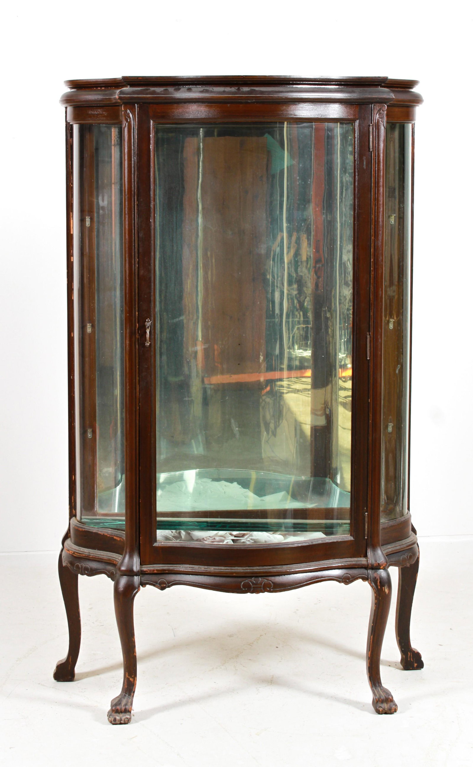 Mahogany carved curved glass china cabinet: Mahogany carved curved glass china cabinet, serpentine door, s-bend sides, mirrored back, glass shelves, on paw feet, 61"h x 36"w x 20"d