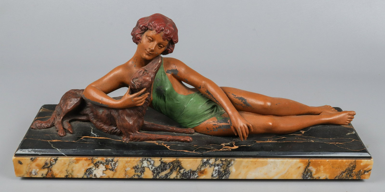 Art Deco White Metal Female with Borzoi: Art Deco white metal female with borzoi, yellow marble raised white metal sculpture of reclined woman in draped cloth with borzoi, 21" L, unsigned, losses to paint.Cracks and hairlines to woman's face