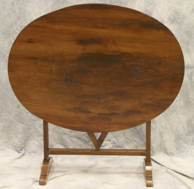 Oval walnut tilt top French wine tasting table in : Oval walnut tilt top French wine tasting table in a trestle base, 42 3/4" oval top x 31 1/2" x 29"h