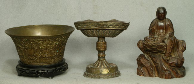Brass Southeast Asian bowl depicting Buddha and ot: Brass Southeast Asian bowl depicting Buddha and other religious figures, set with turquoise, on wood base, 7 3/4" d, with an early stamped brass lighting vessel, 6" tall and a crved wood Buddha, 7 1/2