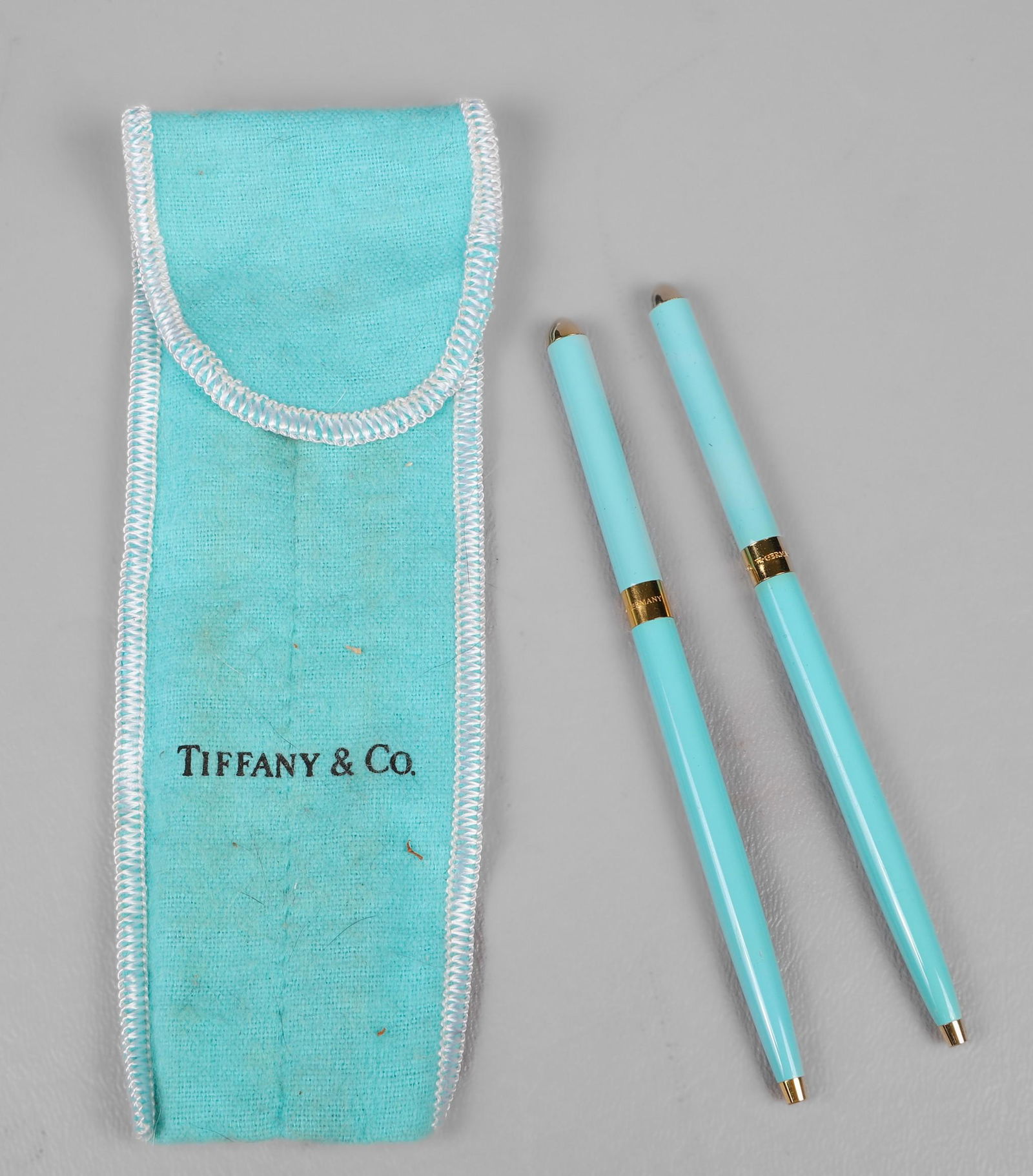 (2) Tiffany & Co Enamel Purse Pens: (2) Tiffany & Co blue enamel purse pens, made in W Germany, 4-1/8" l, with flannel pouch