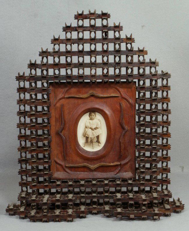Carved tramp art crown of thorns frame, stepped bo: Carved tramp art crown of thorns frame, stepped bottom, peaked top, containing a photo of a child, 16 1/4" x 16 3/4", 6" x 4 1/2" opening