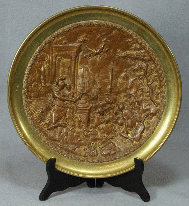 Bronze & brass plaque depicting a Roman garden sce: Bronze & brass plaque depicting a Roman garden scene, 12 3/4" d, scene with musician, a centurion with a woman, cherub in flight, lizard, turtle, and grasshopper on ground, great detail!!
