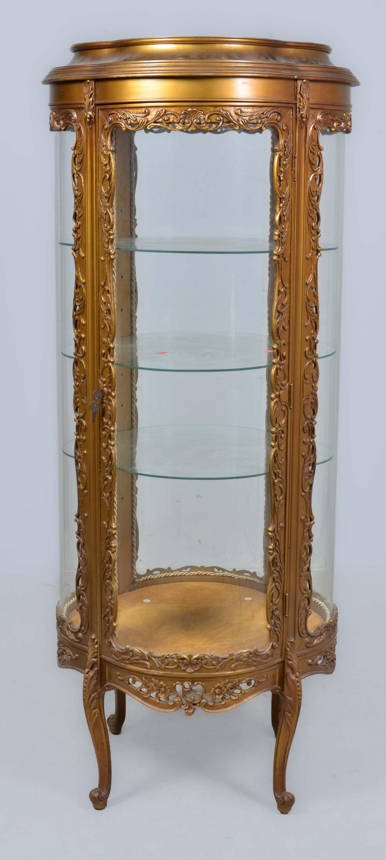 Louis XV style gilt wood quatrefoil shaped vitrine: A Louis XV style carved gilt wood quatrefoil shaped vitrine, second half 20th century, fitted with three shaped glass shelves, height 63 in; width 26in; depth 26in