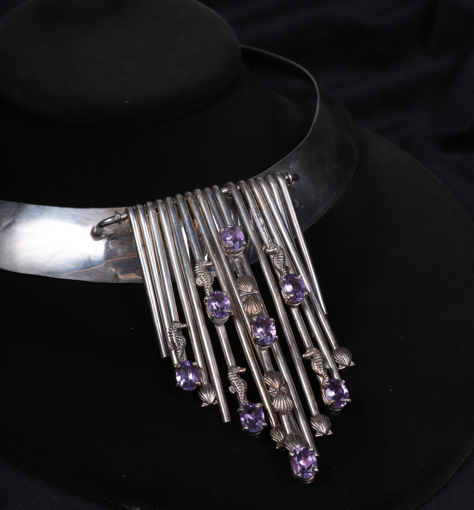 Sterling Collar Necklace: Sterling Collar Necklace, 16 graduated rods hanging, decorated with 6 seahorses, 7 shells, 8 oval light amethyst color oval stones, signed, 6" d at back, 9" overall ht, 3.1 TO
