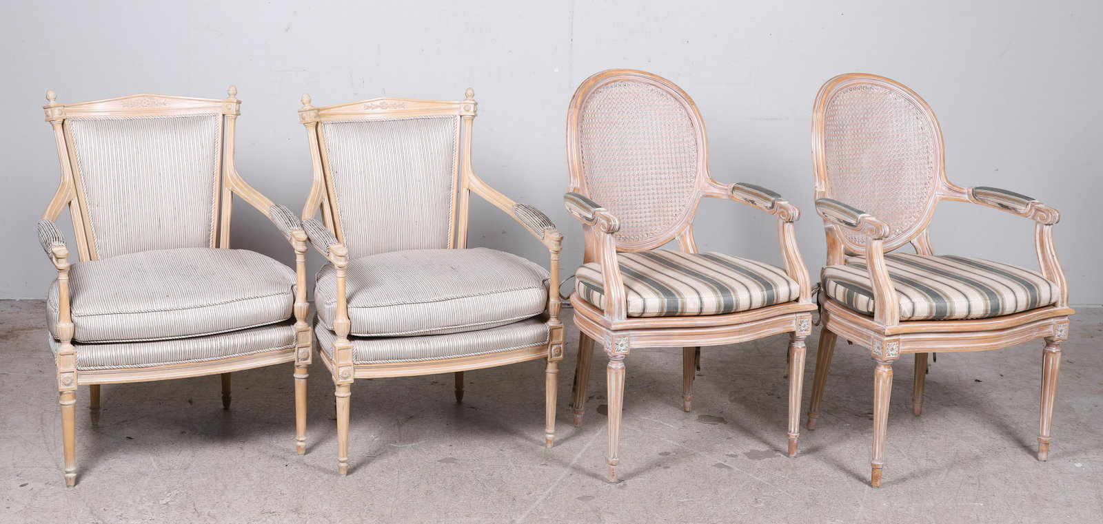 (2) Pairs of Louis XVI Style Fauteuils: (2) Pairs of Louis XVI Style Fauteuils, Comprised of two pairs of fauteuils, the first pair of carved and stained wood with upholstered seats, armrests, and backs with loose seat cushions, the second 