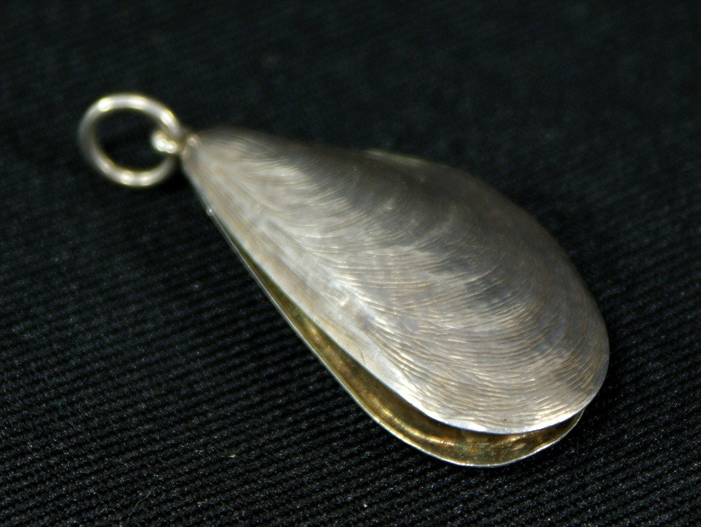 Victorian gilt-lined vinaigrette stamped S Mordan &: Victorian gilt-lined vinaigrette stamped S Mordan & Co, London, in the form of a mussel shell, the exterior realistically engraved, the grill pierced and with engraved flowers and foliage, 2-7/8" l, c