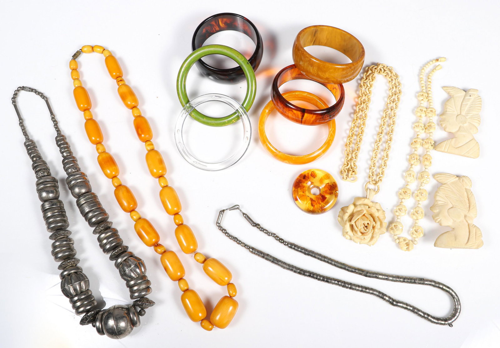 Bakelite, Silver and Bone: Bakelite, silver and bone jewelry to include pair figural bone pins, (2) carved bone necklaces, (2) silver tone necklaces, amber tone bead necklace, (6) bangles, (1) in green bakelite and amber style 