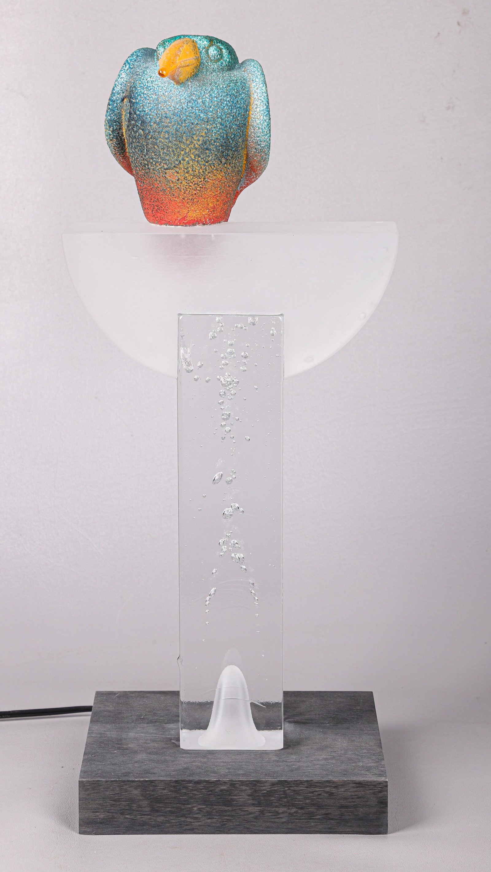Kosta Boda Kjell Engman Art Glass Sculpture: Kosta Boda Kjell Engman art glass sculpture, art glass bird in mottled ombre decoration on frosted demi-lune perch, raised on colorless glass stand with lighted fitted wood stand, sculpture, 18-7/8"H,