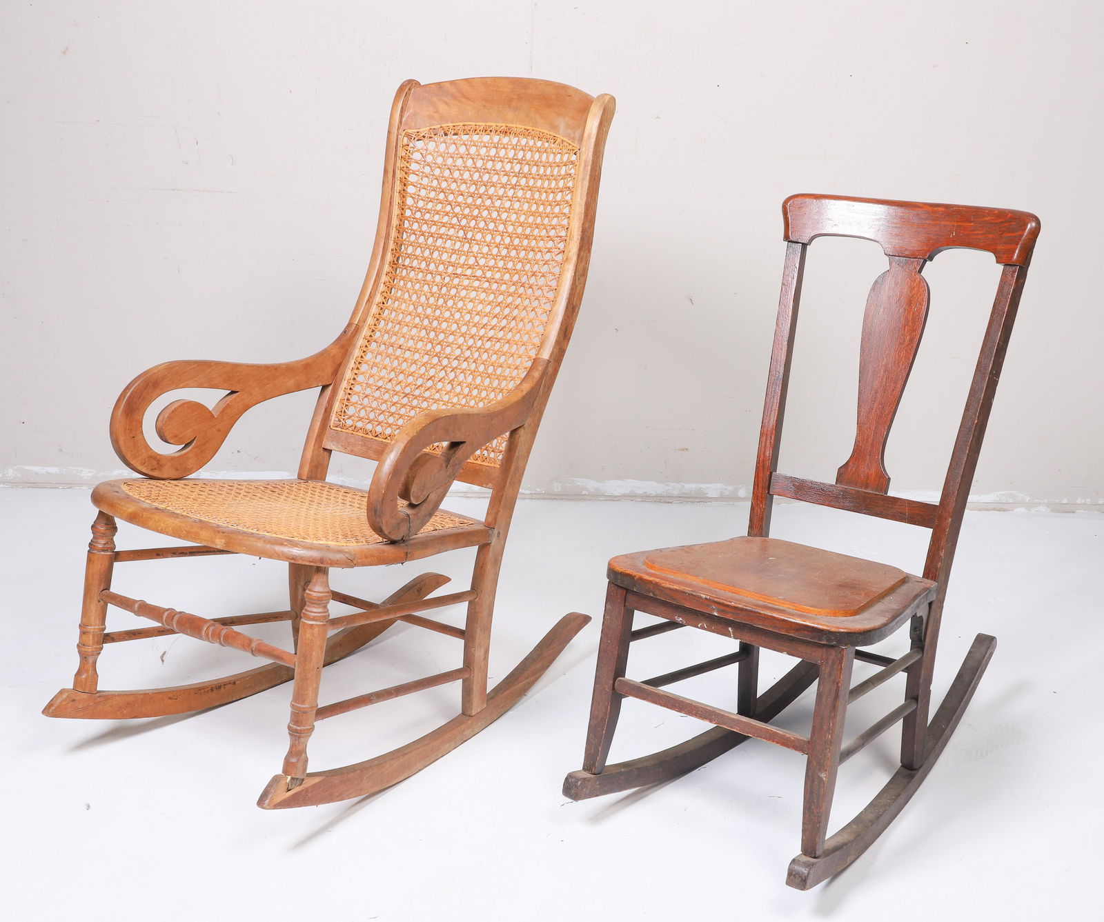 (2) Rocking chairs: (2) Rocking chairs, c/o Empire style maple caned back and seat, scrolled arms, Oak carved rocker, largest 40"h x 24"w x 37"d