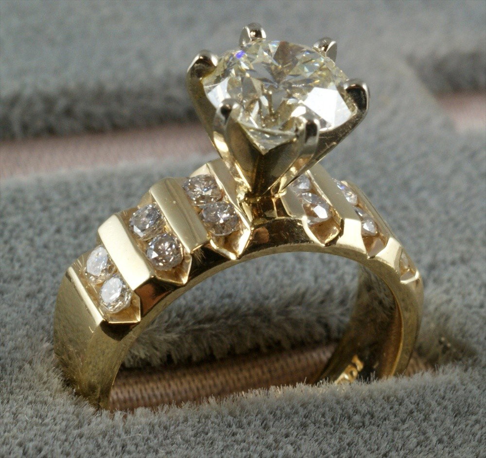 14K YG diamond engagement ring, 2.0 carat center: 14K YG diamond engagement ring, 2.0 carat center stone, color is graded as "L" GIA while set with negligible UV florescence, the clarity graded currently as SI2, with 12 round diamonds app 0.55ctw, mo