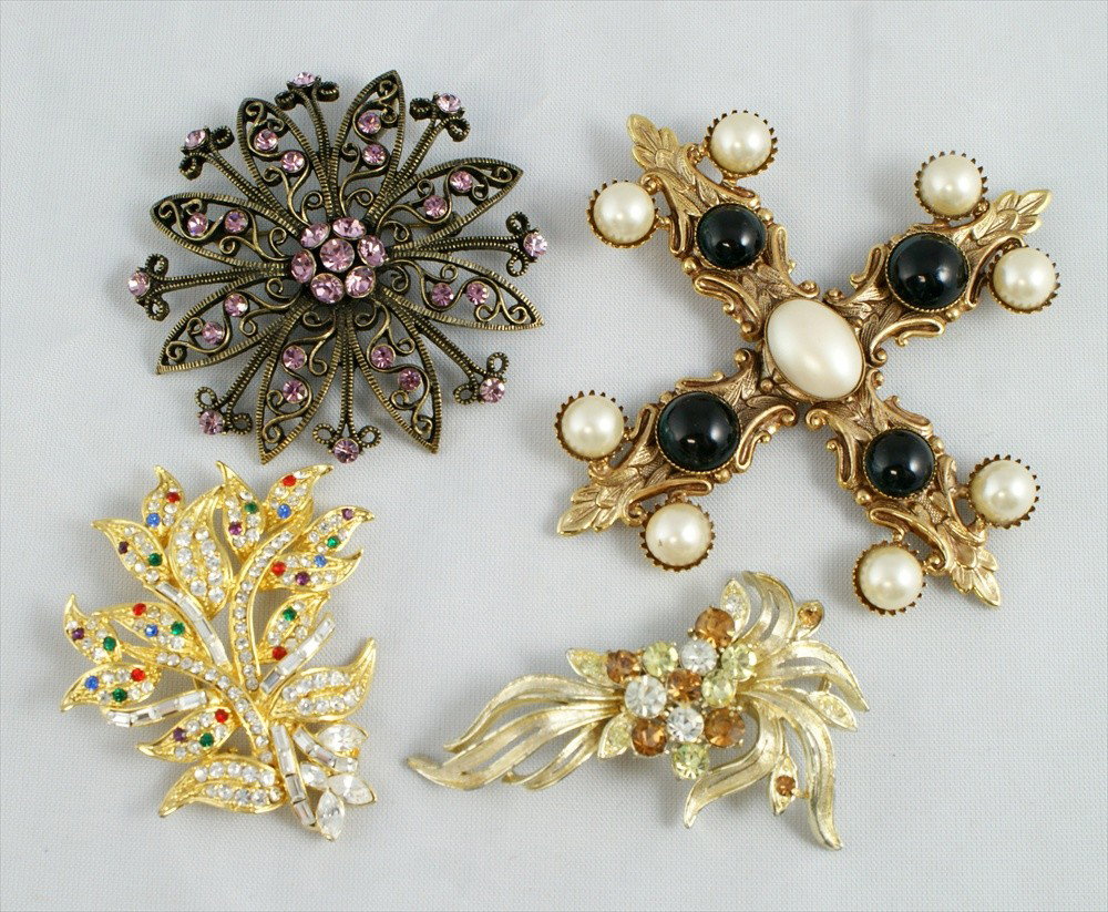 4 piece costume jewelry lot consisting of Coro g: 4 piece costume jewelry lot consisting of Coro gold tone rhinestone spray pin, 3" L, unsigned gold tone faux pearl and green stone cross pin, 4" L, unsigned gold tone rhinestone floral spray pin, 2.5"