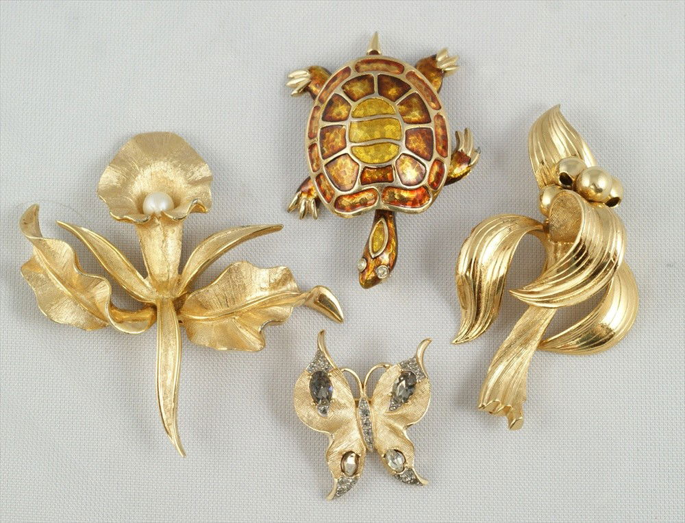 4 piece costume jewelry lot consisting of Trifar: 4 piece costume jewelry lot consisting of Trifari gold tone butterfly pin, Napier gold tone flower pin, 2" L, Boucher gold tone faux pearl lily pin, 2" L and Boucher gold tone turtle pin, 2" L