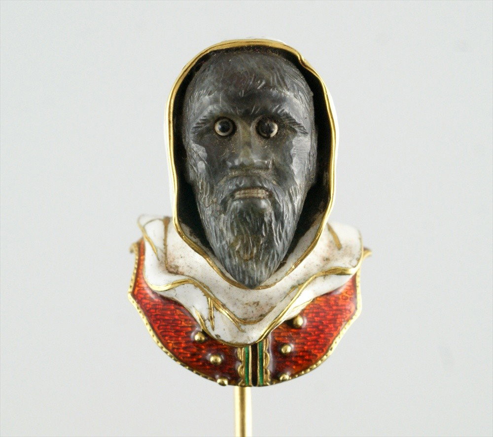 Unmarked YG enameled stickpin of a hooded Arab m: Unmarked YG enameled stickpin of a hooded Arab man's head, the face with small set stone eyes and enameled teeth, 8.0 dwt, 1 1/8" h, 3/4" w at shoulders, an extraordinary stickpin!! With original gree