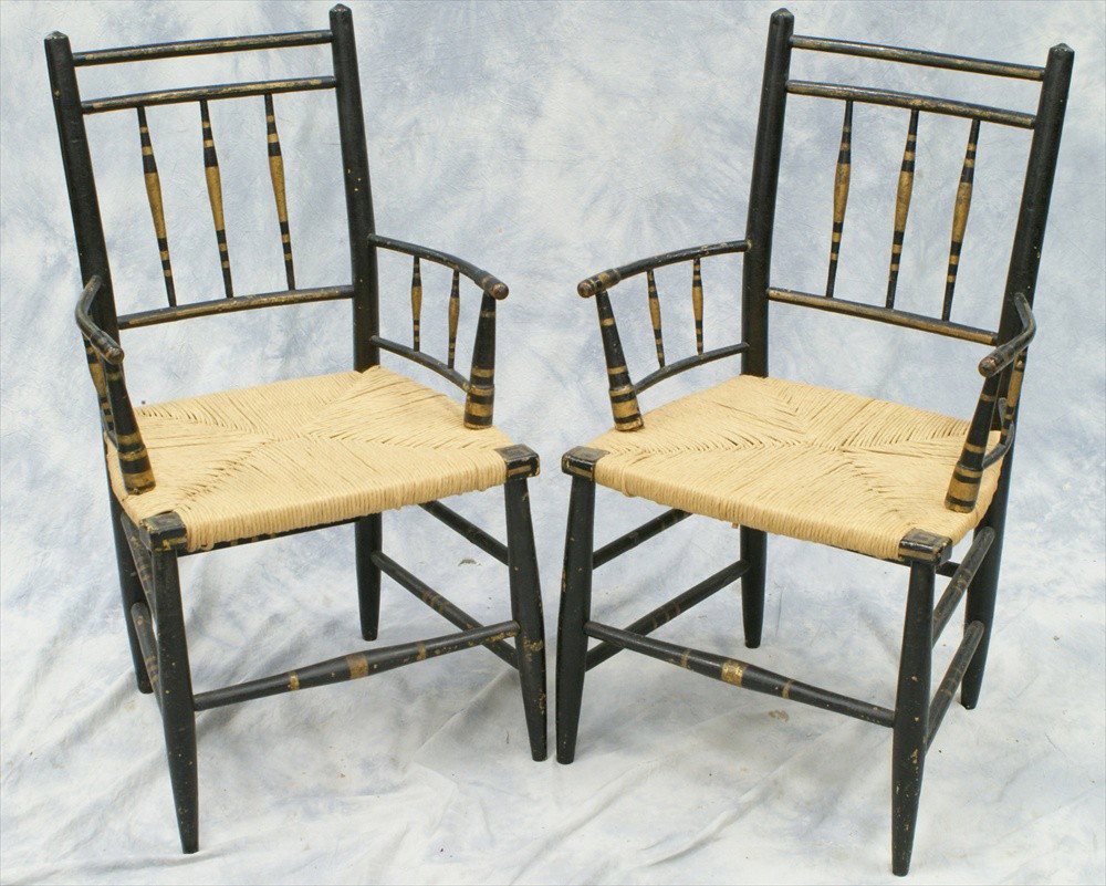 Pr black painted Sheraton armchairs with rush s: Pr black painted Sheraton armchairs with rush seats, gold trim, early 19th c