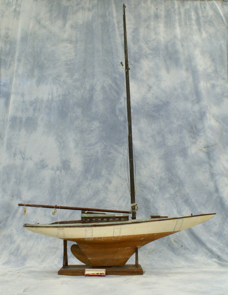 Single masted wooden pond boat, lacking most of: Single masted wooden pond boat, lacking most of the rigging, sails, and some other parts, 56" long, 84" high, along with a bosun's whistle and a small nautical 13 star and anchor US flag