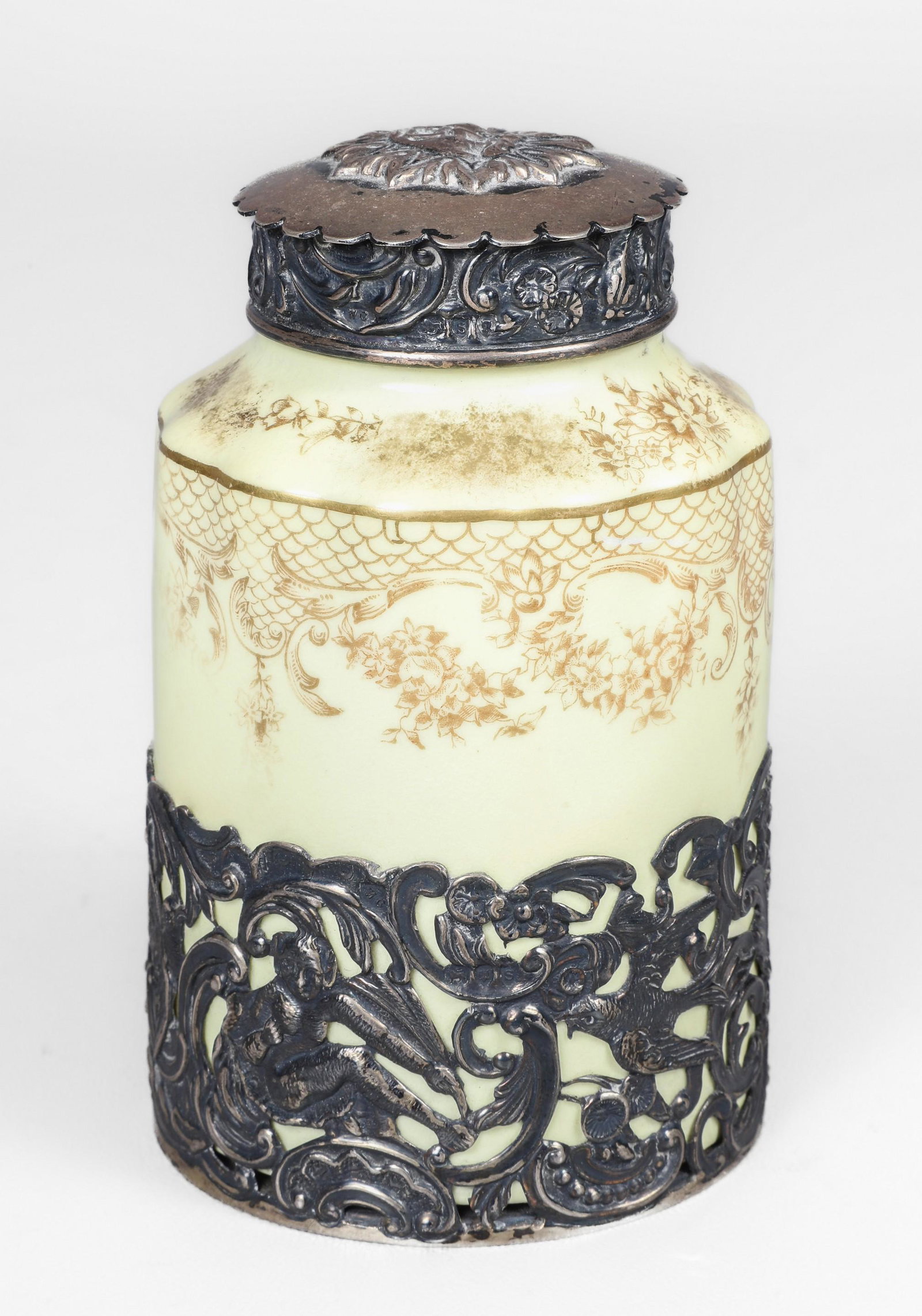 Pierced Silver Mounted Porcelain Tea Caddy: Pierced silver mounted porcelain tea caddy, 1899-1905 Crown Staffordshire porcelain caddy , in pierced silver mount depicting birds, devil, cherubs and scrolls, the lid in repousse open mouth sun face