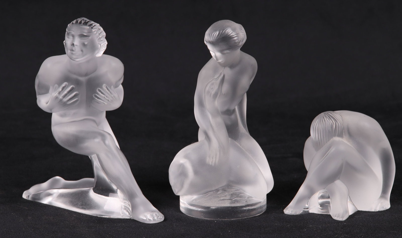 (3) Lalique Figures: (3) Lalique figures to include Leda and the Swan, 4-7/8"H, seated nude, 2-1/2"H, and kneeling nude, 4-3/4"H, chip major on lady and swan, small chips to bases of others, person with face between legs 