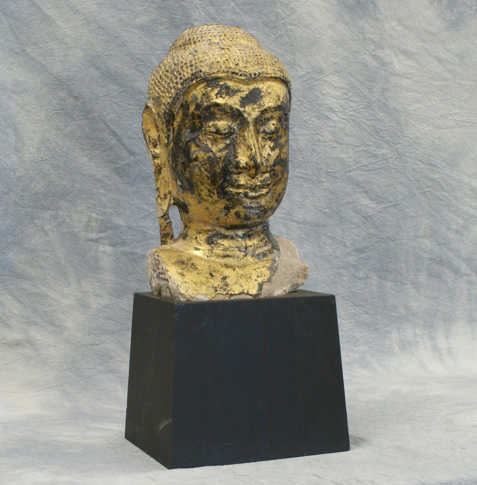 Lacquered Stone Head Of Buddha, probably Burmese,: Lacquered Stone Head Of Buddha, probably Burmese, 18th century or earlier, head approx 14" high, together with a wooden stand that is 8" high, loss to lacquer