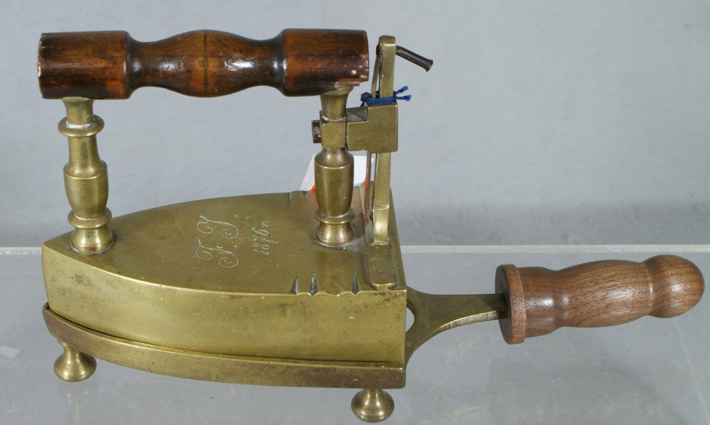 Brass box slug iron with rising gate, initialed &: Brass box slug iron with rising gate, initialed & dated TT, 1876, wood handle, on a trivet with wood handle