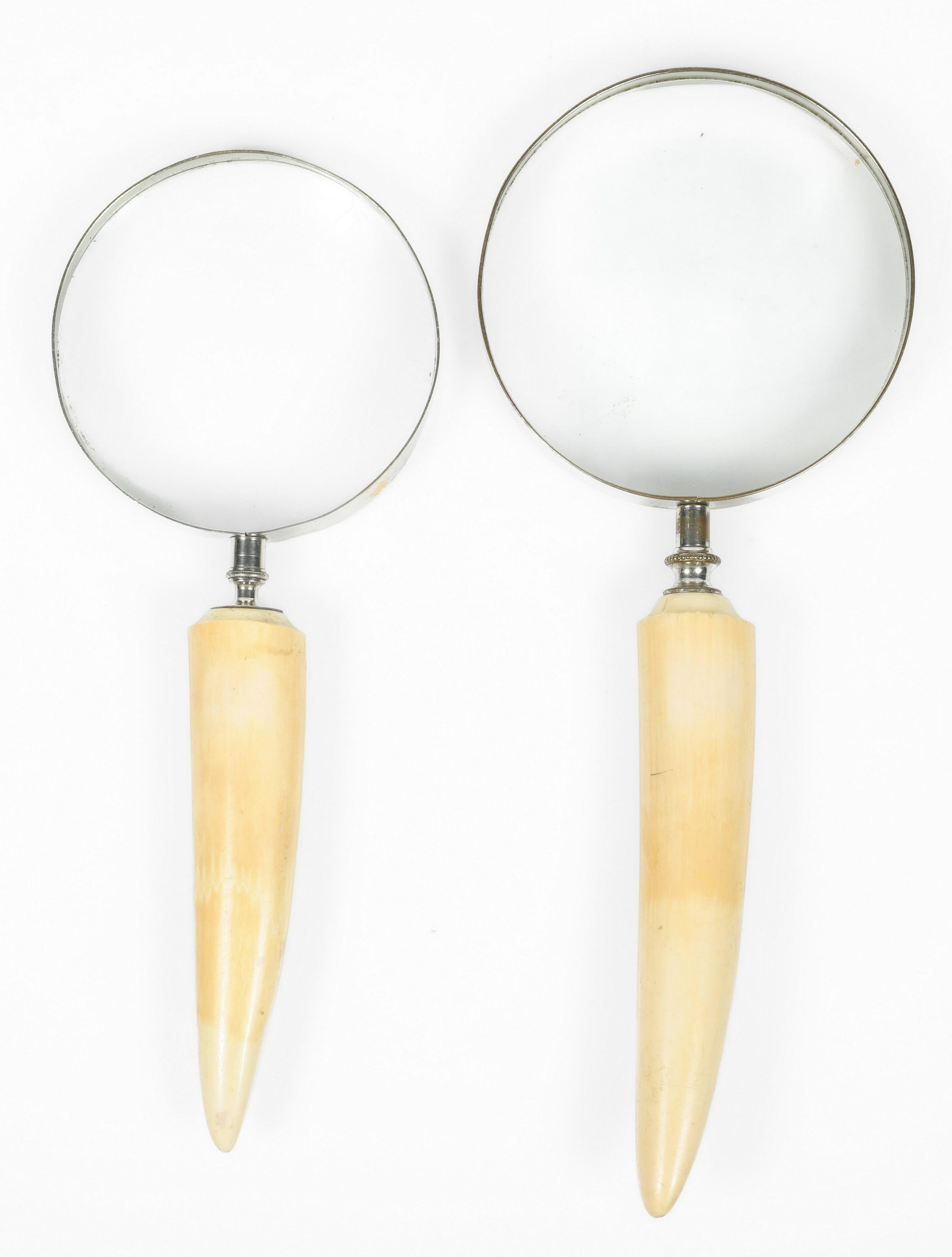 Two bone-handled desk magnifying glasses: Two large bone- or celluloid-handled desk magnifying glasses, 20th century.