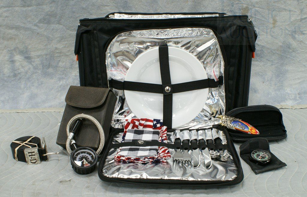 Harley Davidson lot including a waterproof picnic b: Harley Davidson lot including a waterproof picnic bag, with plates, utensils, cups, salt and pepper and more, a leather belt with HD buckle, HD tire pressure gauge with case, HD tire tread depth gauge