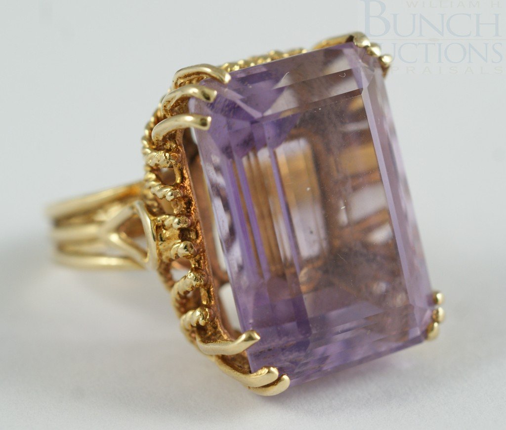 14K YG and amethyst ladies ring, emerald cut ston: 14K YG and amethyst ladies ring, emerald cut stone measuring 21.5 x 14 mm, calculating about 21 carat, size 6, 7.8 dwt gross weight