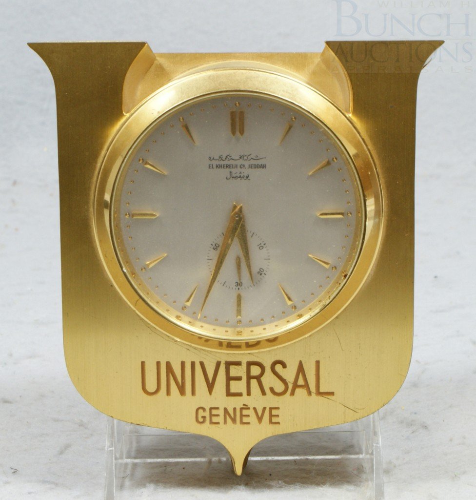 Universal Geneve brass wall clock with battery op: Universal Geneve brass wall clock with battery operated mechanical movement, dial marked El Khereiji Co, Jeddah, (a Saudi Arabian general contractor), 6 1/4" h, runs when powered with a single D cell