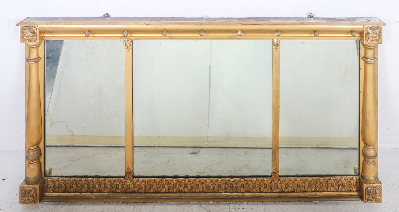 Gilt hanging mantle mirror: Gilt hanging mantle mirror, floral decoration with rosettes at corners flanked by turned columns, 30" x 53", composition, some damages to frame