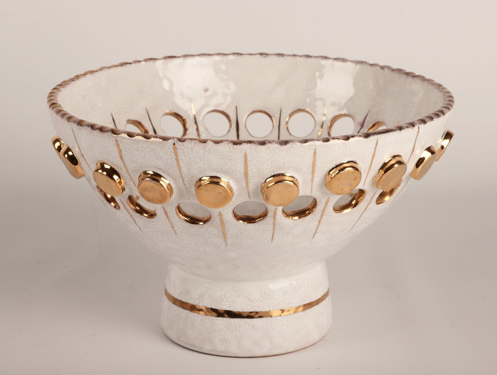 Bitossi Italian Pottery Bowl: Bitossi Italian pottery footed bowl, white glaze with gold trim, pierced circles around bowl, marked "95/14G Italy", 9" dia x 5-5/8" h, chip to underside of base