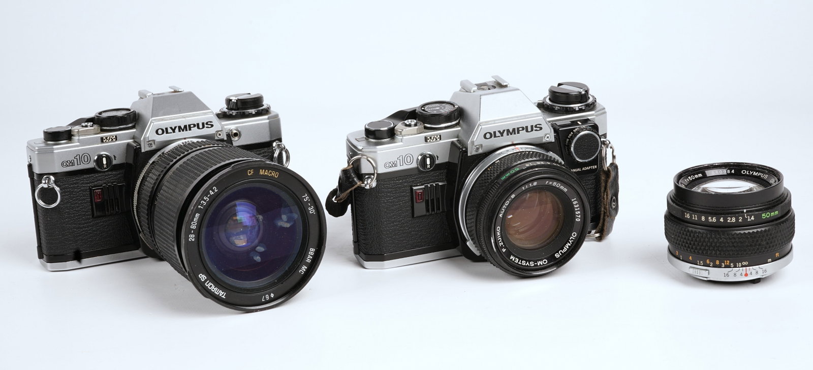 (2) Olympus OM10 35 mm Film Cameras: (2) Olympus OM10 35 mm Film Cameras, (1) with f. Zuiko 50 mm f1.8 lense, (1) with Tamron 25-80 mm zoom f3.5-4.2. Also to include a third lense, f. Zuiko 50mm f1.4