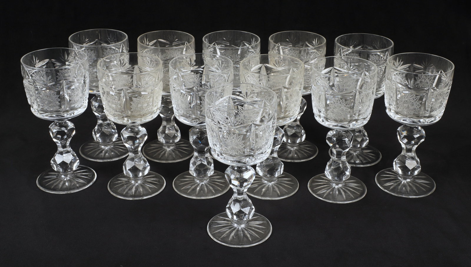 (12) Cut glass wine stems: (12) Cut glass wine stems, paneled hobstar bowl, cut hourglass form stem, star cut base, unsigned, 6-1/2" h