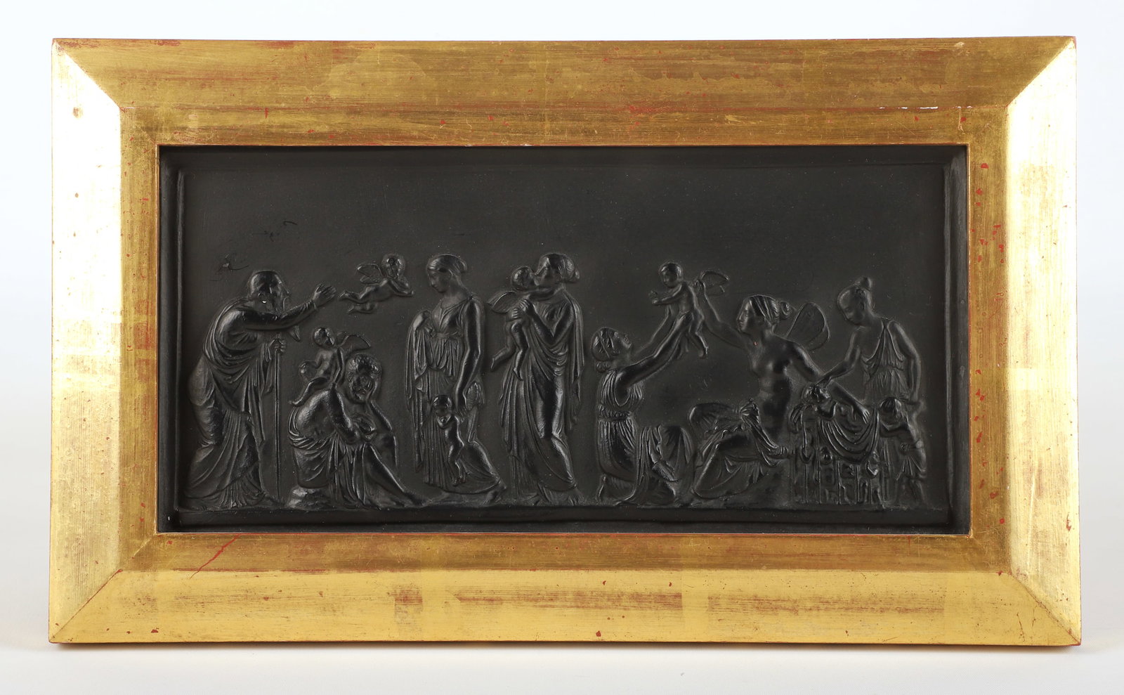 Basalt porcelain Grecian plaque: Basalt porcelain Grecian plaque, men & women with cherubs, unmarked, 4-3/4" x 9-1/2" sight, 7" x 12" overall, scratch (upper left) that appears to have been covered with black marker (see photo), ligh