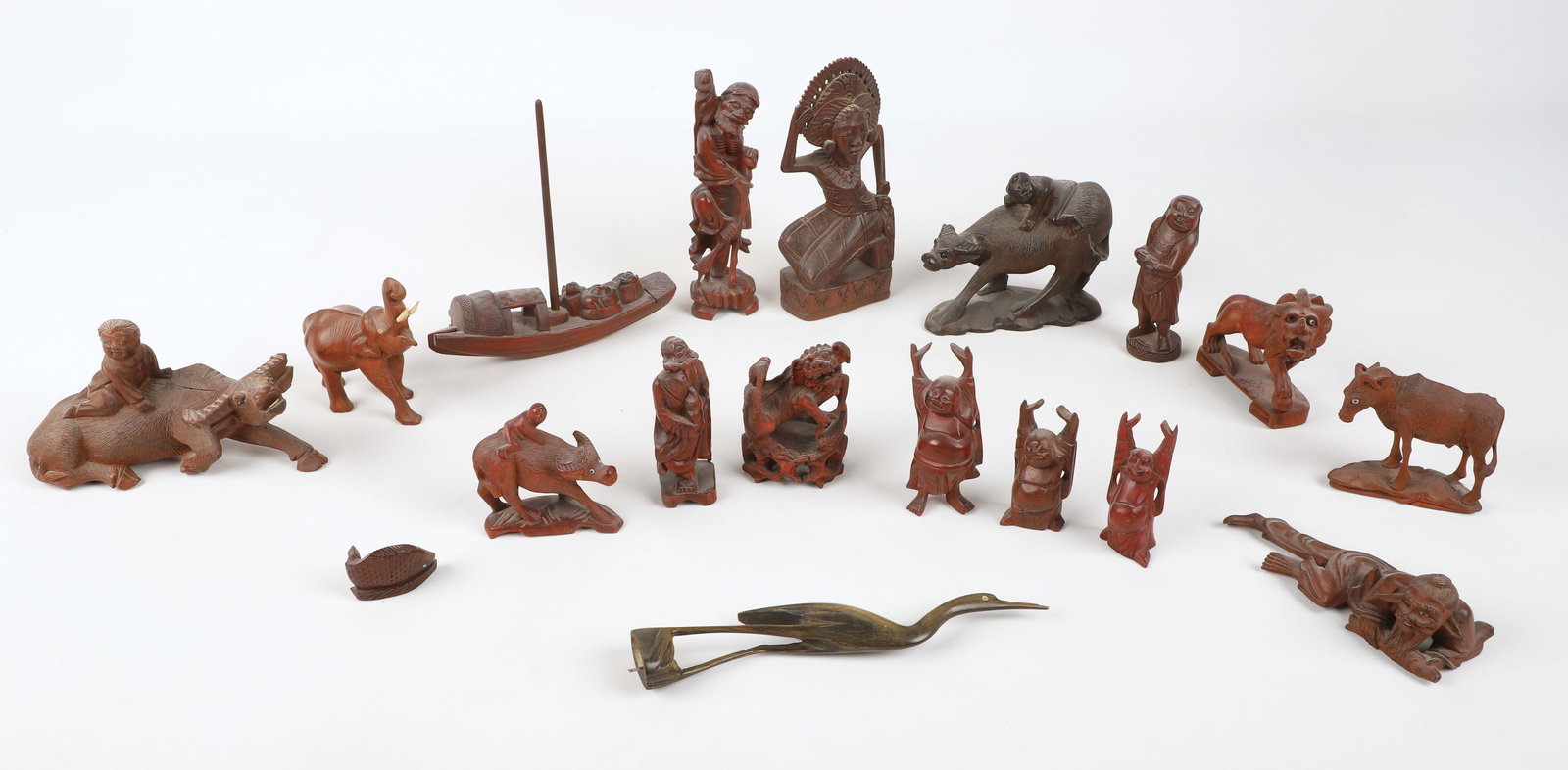 (17) Chinese carved figures: (17) Chinese carved figurines, including (3) wood water buffalo with child (largest 7" w x 3-3/4" h), foo dog (3-1/2" h), lion (3-1/2" h), goat (3" h), elephant (4" h), fish (1-1/4" h), (3) Buddha wit